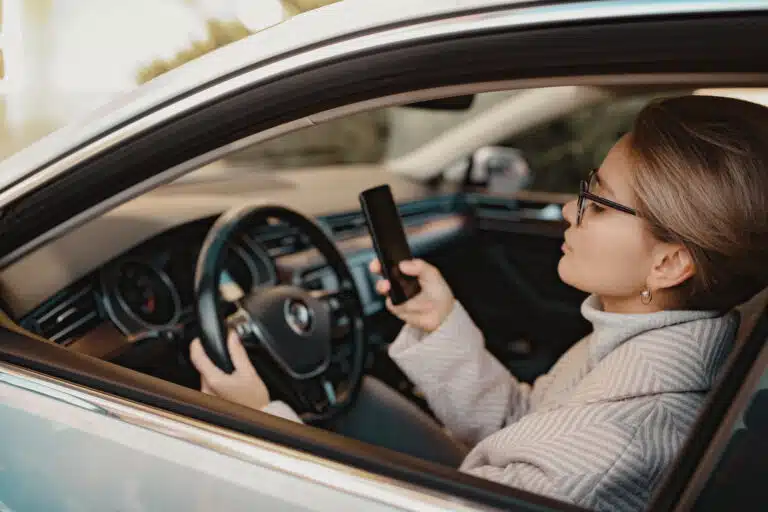 Person on the Phone Texting and Driving | Distracted Driving Impacts | ATA Associates